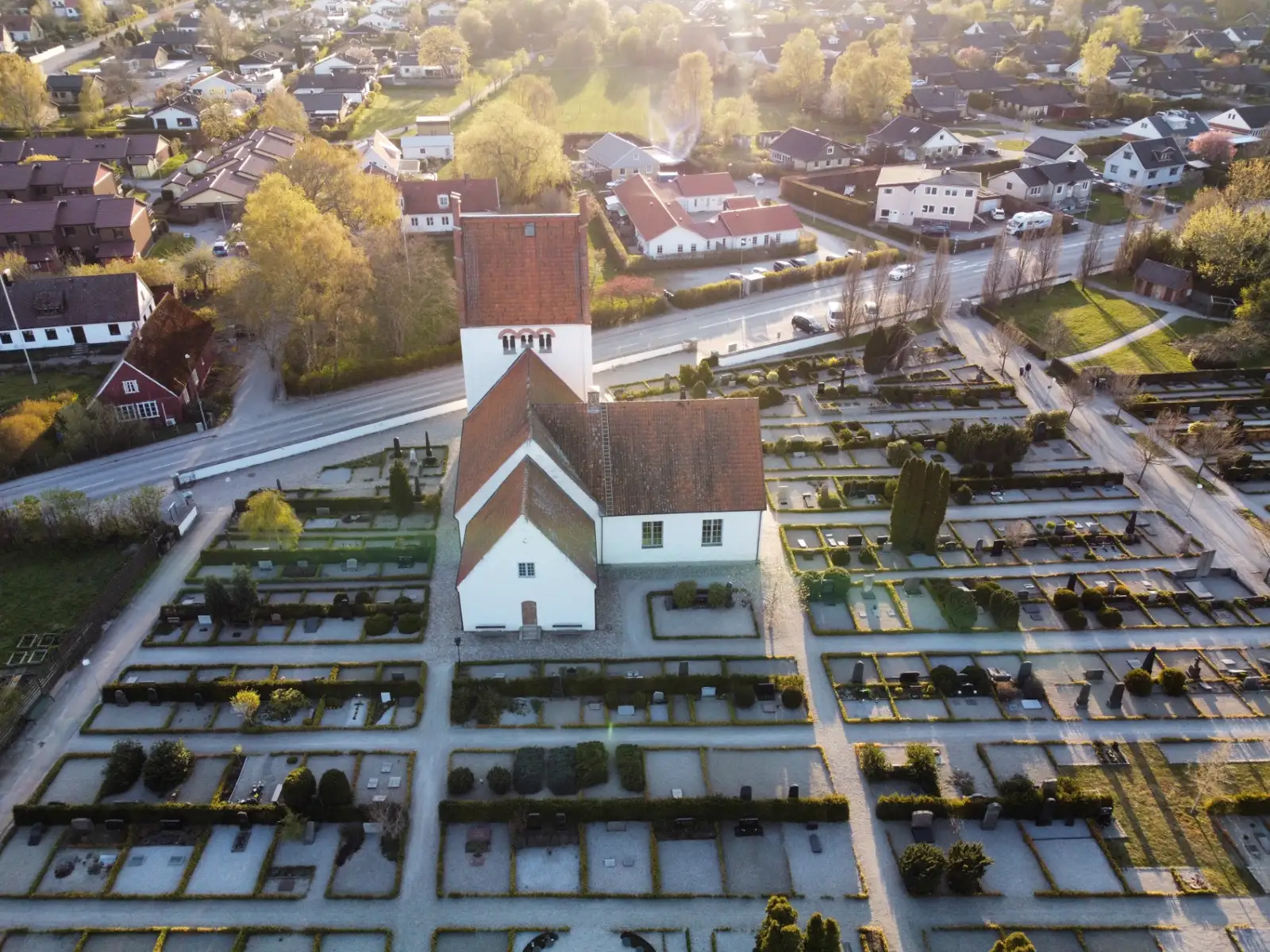 Drönarfoto på kyrka med kyrkogård i kvällsljus